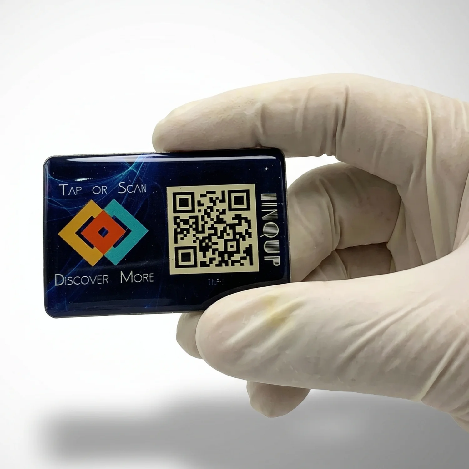 LINQS smart NFC and QR dynamic sticker held in gloved hand for size reference